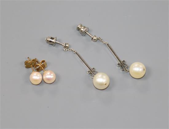 Two pairs of cultured pearl earrings including white metal drop earrings.
